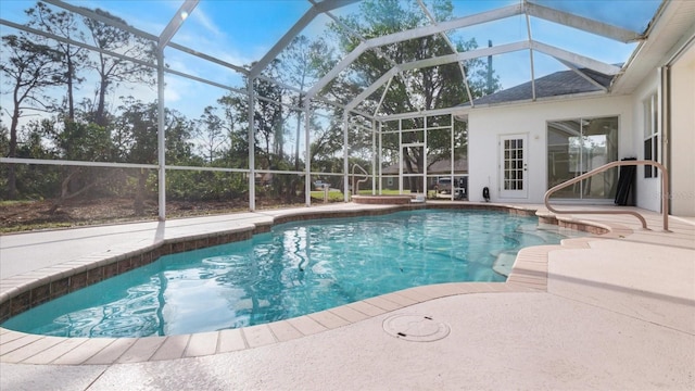 pool featuring glass enclosure and a patio area