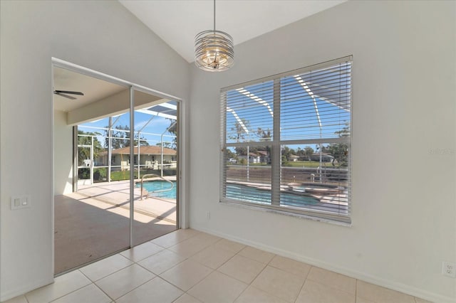 tiled spare room featuring lofted ceiling, ceiling fan, a sunroom, and baseboards