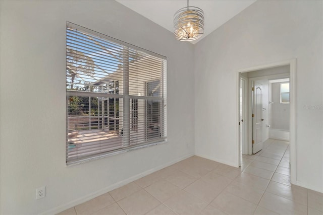 unfurnished room featuring vaulted ceiling, tile patterned flooring, a wealth of natural light, and baseboards