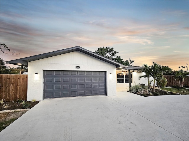 single story home featuring stucco siding, driveway, an attached garage, and fence