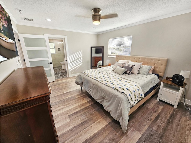 bedroom with crown molding, visible vents, ceiling fan, a textured ceiling, and wood finished floors