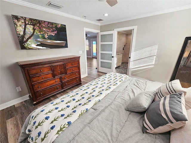 bedroom featuring dark wood-style floors, visible vents, ornamental molding, and a textured ceiling