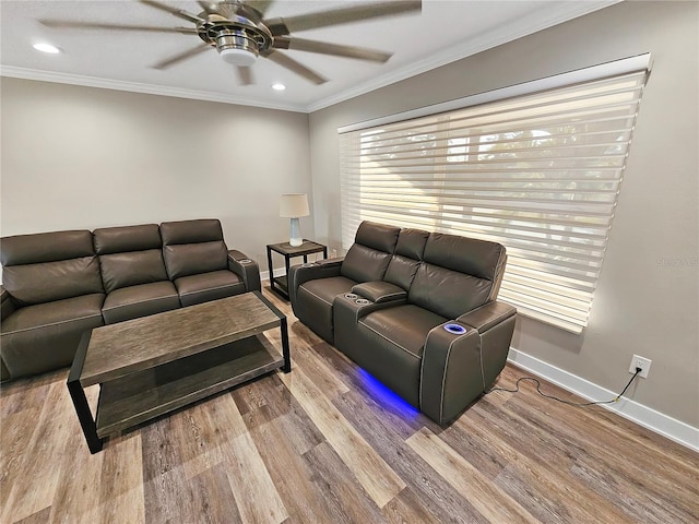 living room featuring a ceiling fan, light wood-type flooring, crown molding, and baseboards