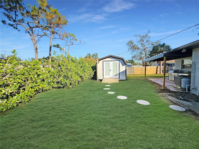 view of yard featuring a shed, fence, and an outbuilding