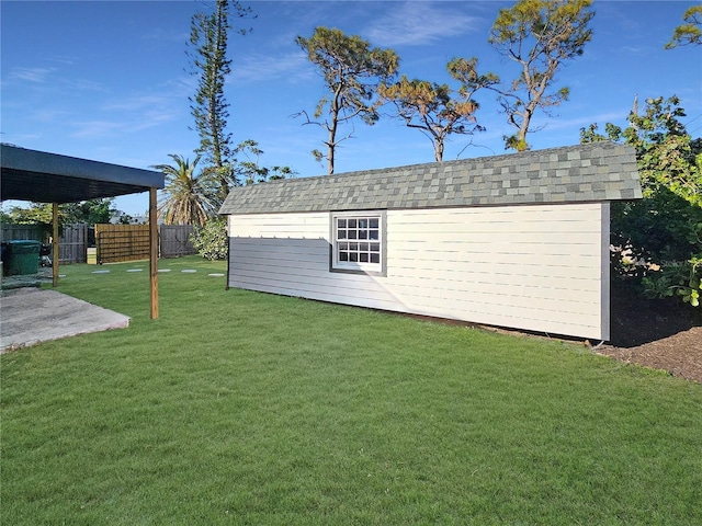 view of outdoor structure with fence and an outbuilding