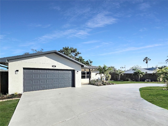 ranch-style home featuring concrete driveway, an attached garage, fence, and stucco siding