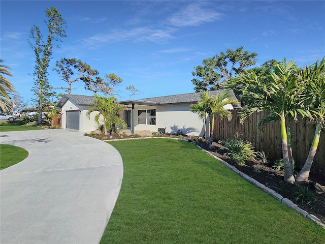 view of front facade featuring a garage, fence, concrete driveway, stucco siding, and a front lawn