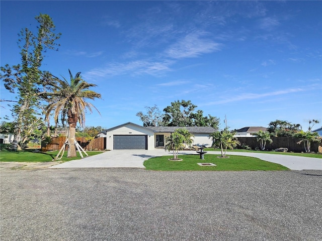 view of front of house featuring a garage, a front yard, driveway, and fence