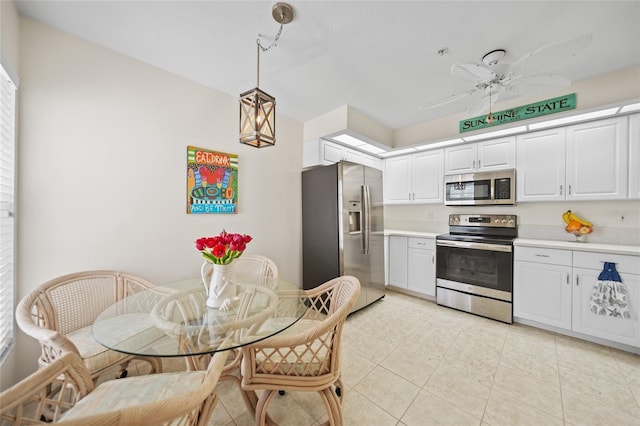 kitchen featuring appliances with stainless steel finishes, decorative light fixtures, light countertops, white cabinetry, and light tile patterned flooring