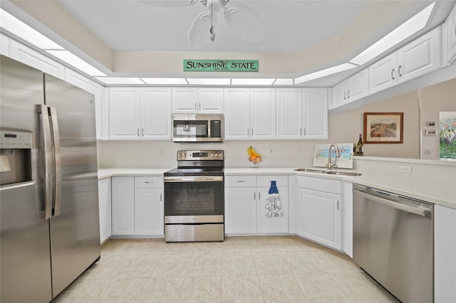 kitchen with stainless steel appliances, light countertops, and white cabinetry