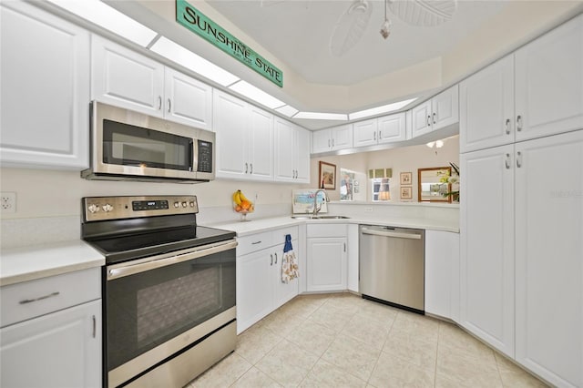 kitchen with stainless steel appliances, light countertops, and white cabinetry