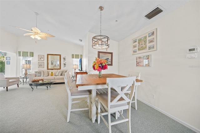 dining room with light carpet, a ceiling fan, visible vents, vaulted ceiling, and baseboards