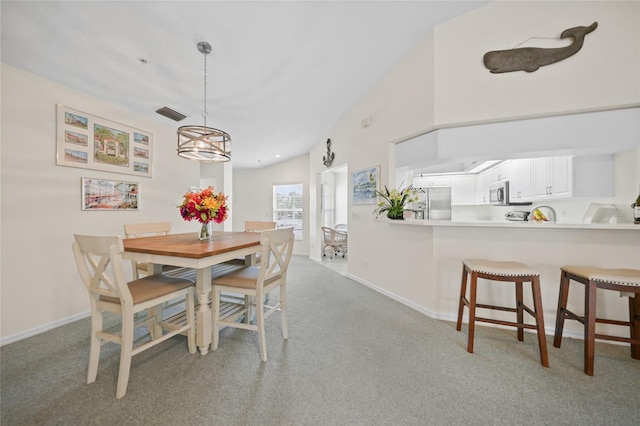 dining space featuring baseboards, visible vents, and light colored carpet