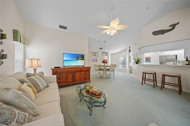 living room featuring light carpet, high vaulted ceiling, visible vents, and a ceiling fan