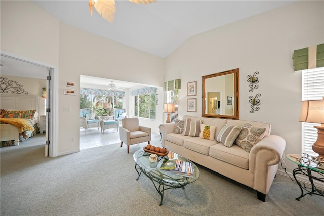 living area with light carpet, high vaulted ceiling, and a ceiling fan