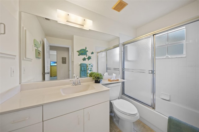 full bath with toilet, visible vents, bath / shower combo with glass door, and vanity