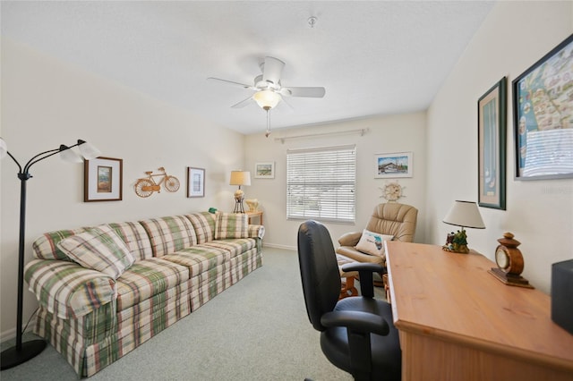 carpeted office with baseboards and a ceiling fan