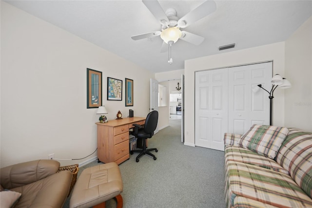 office space featuring ceiling fan, visible vents, dark carpet, and baseboards