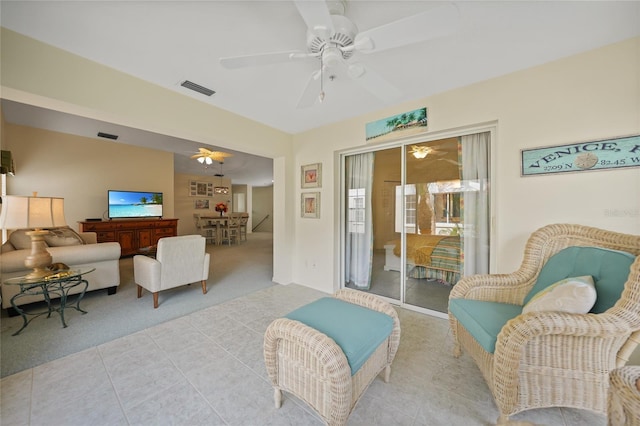 living area with ceiling fan, light tile patterned floors, light carpet, and visible vents