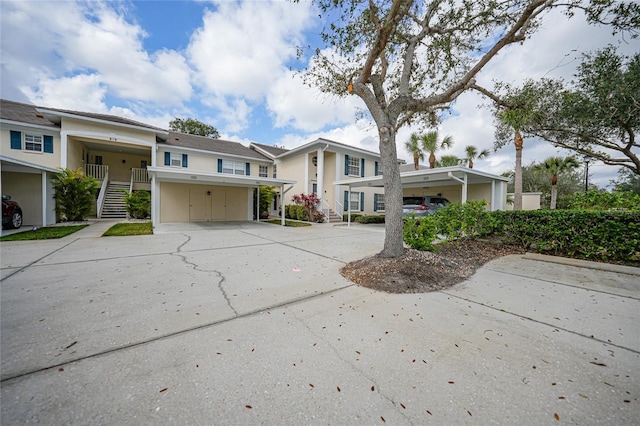 view of front of house featuring a carport, stairway, and concrete driveway