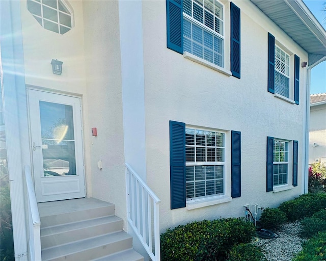 doorway to property featuring stucco siding