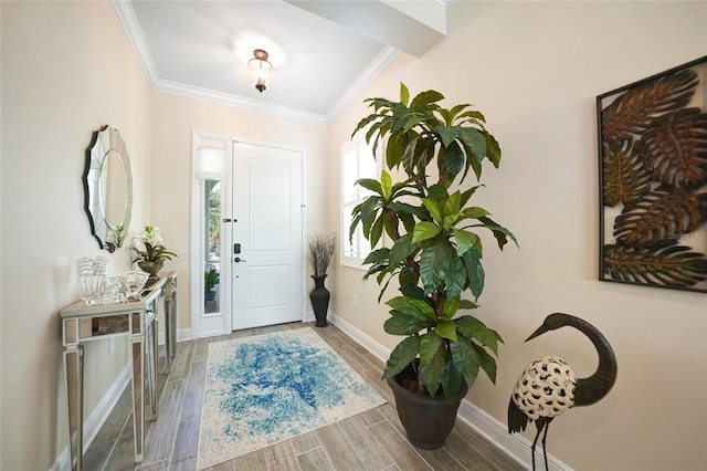 foyer featuring baseboards, crown molding, and wood finish floors