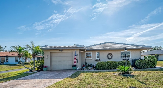 single story home with a garage, a front yard, decorative driveway, and a tile roof