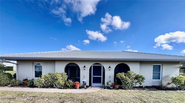 ranch-style home with stucco siding and a tiled roof