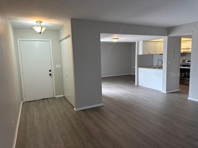 interior space with baseboards and dark wood-type flooring