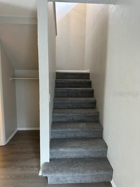 stairs with baseboards and wood finished floors