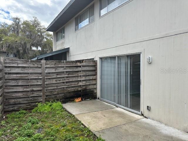 view of side of home featuring a patio area and fence