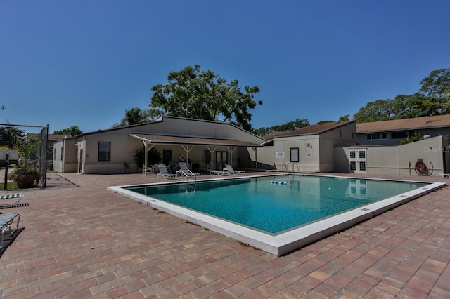 pool featuring fence and a patio