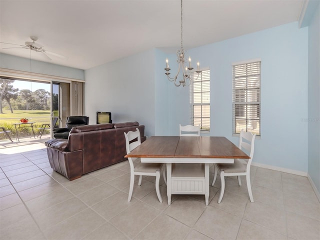 dining room featuring a healthy amount of sunlight, ceiling fan with notable chandelier, baseboards, and light tile patterned flooring