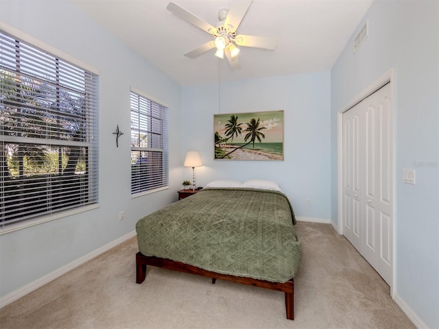 carpeted bedroom featuring a closet, visible vents, and baseboards