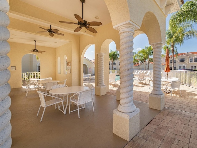 view of patio with a ceiling fan, outdoor dining area, and fence