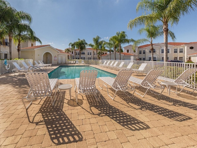 pool featuring a residential view, a patio area, and fence