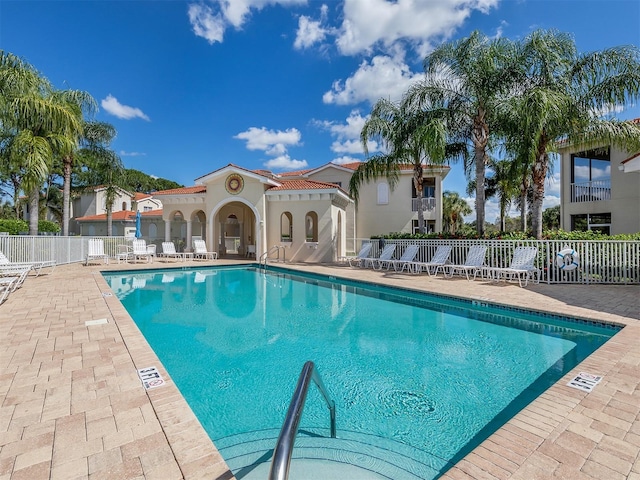 pool with a patio area and fence