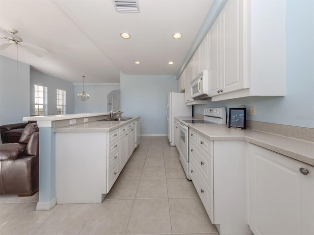 kitchen with white appliances, visible vents, a peninsula, light countertops, and white cabinetry