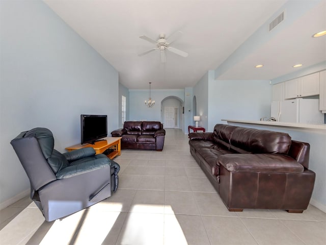 living area featuring visible vents, arched walkways, baseboards, light tile patterned flooring, and ceiling fan with notable chandelier