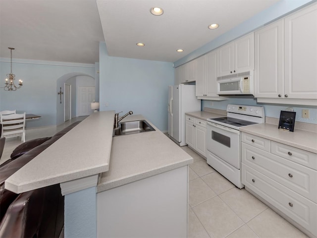 kitchen with a peninsula, white appliances, white cabinetry, light countertops, and pendant lighting