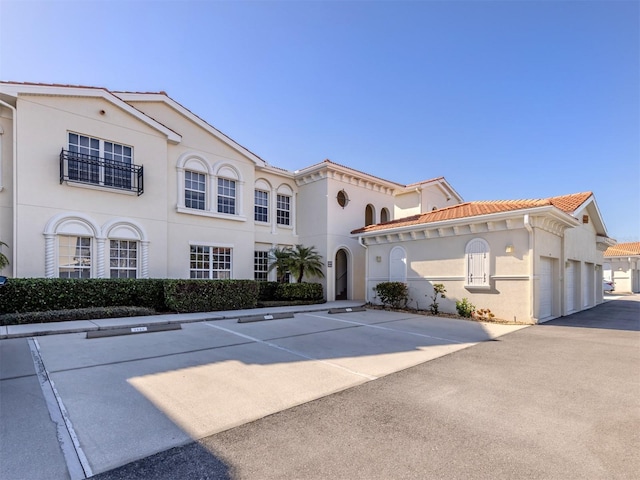 mediterranean / spanish home with a tiled roof and stucco siding