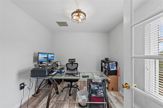 office space with visible vents, baseboards, and wood finished floors