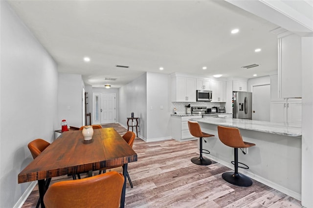 dining space featuring recessed lighting, baseboards, visible vents, and light wood finished floors