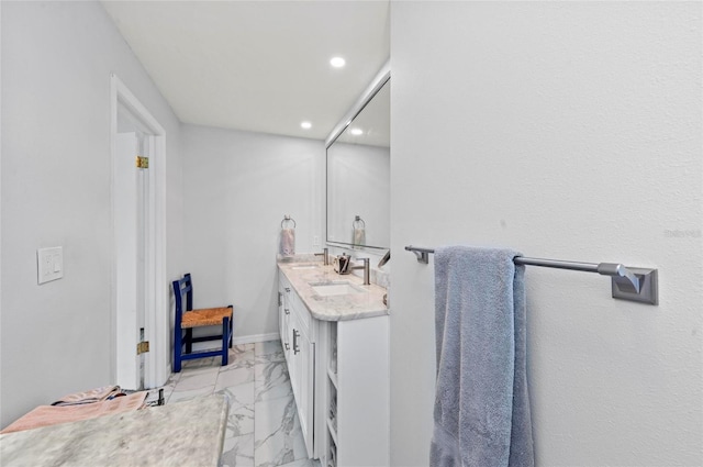 bathroom with recessed lighting, a sink, baseboards, marble finish floor, and double vanity