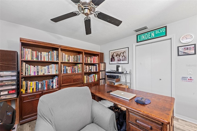 office featuring a ceiling fan, light wood-type flooring, and visible vents