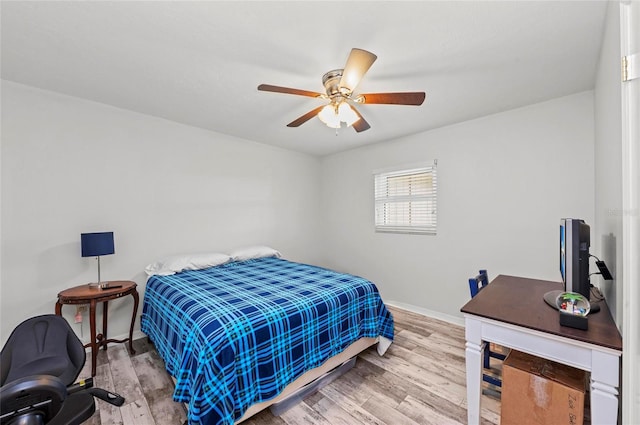 bedroom with ceiling fan, baseboards, and wood finished floors