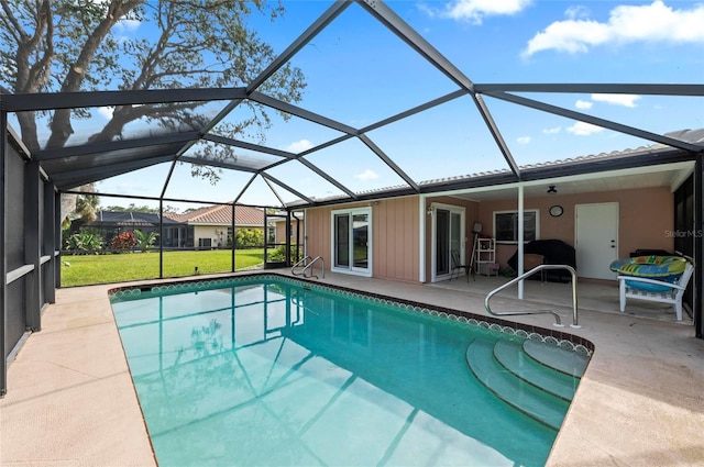 outdoor pool with a lanai, a lawn, and a patio