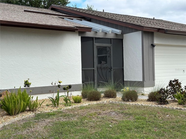 view of home's exterior with a shingled roof, a garage, and stucco siding