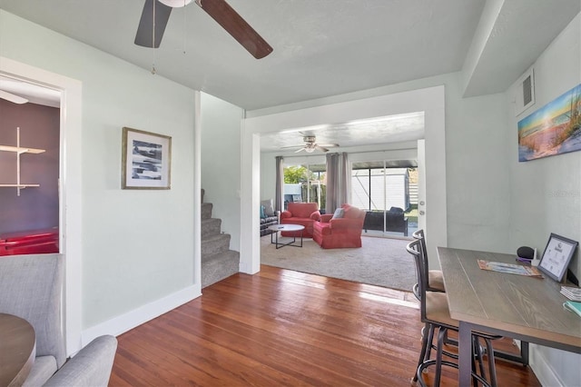 interior space with baseboards, visible vents, ceiling fan, stairway, and wood finished floors