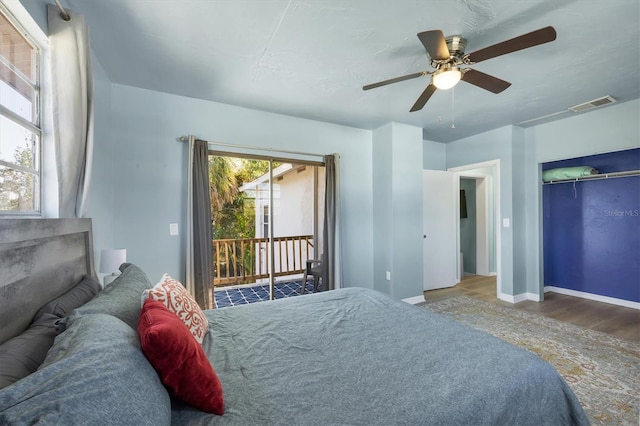 bedroom with ceiling fan, wood finished floors, visible vents, baseboards, and access to outside